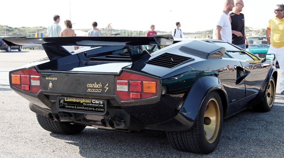 Black Lamborghini Countach 5000 with a large rear wing and gold wheels