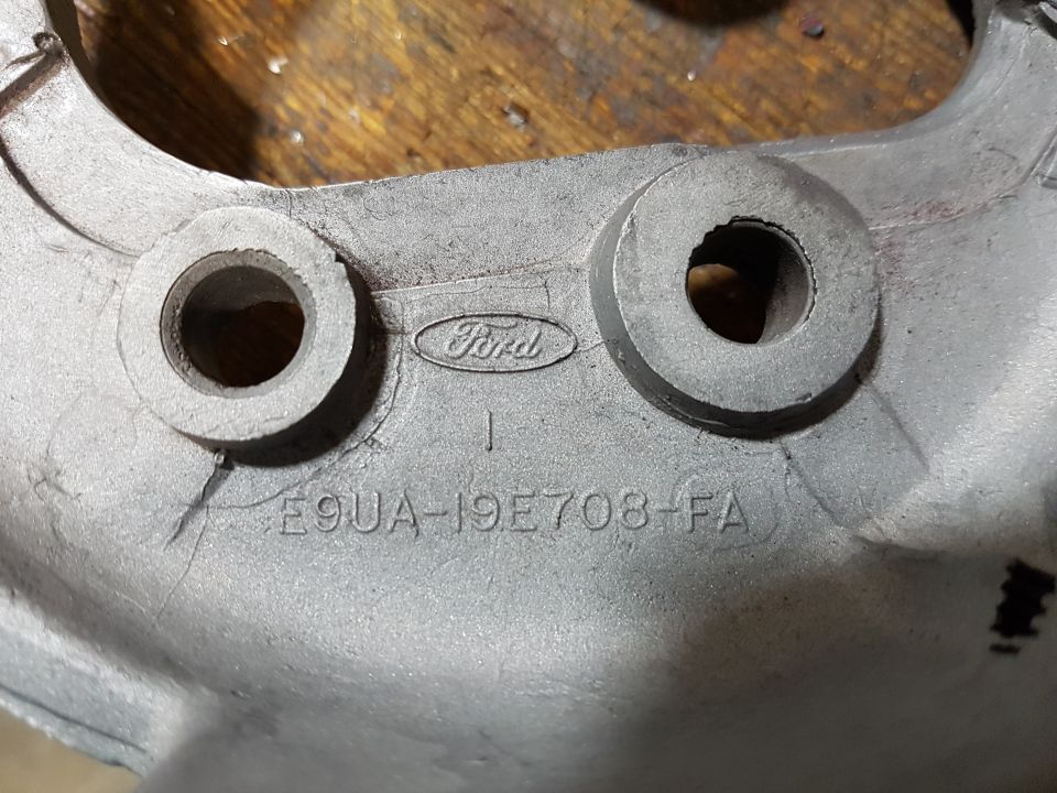 Ford logo and part number E9UA-19E708-FA stamped on a metal vehicle part.