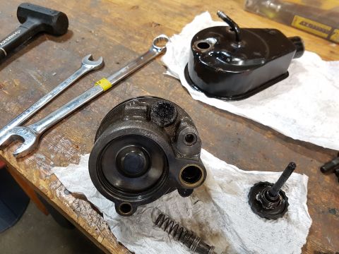 1978 Ford Bronco - A collection of automotive parts, including a power steering pump reservoir, a brake master cylinder, two wrenches, and a rubber mallet, ar…