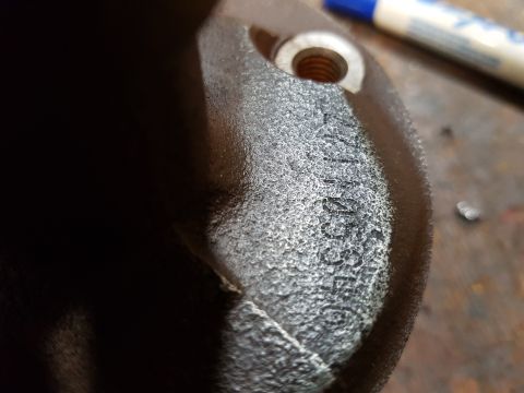 1978 Ford Bronco - A close-up shot shows a textured, dark-colored metal part with embossed text that reads "71855E". A blue and white marker is visible in the…