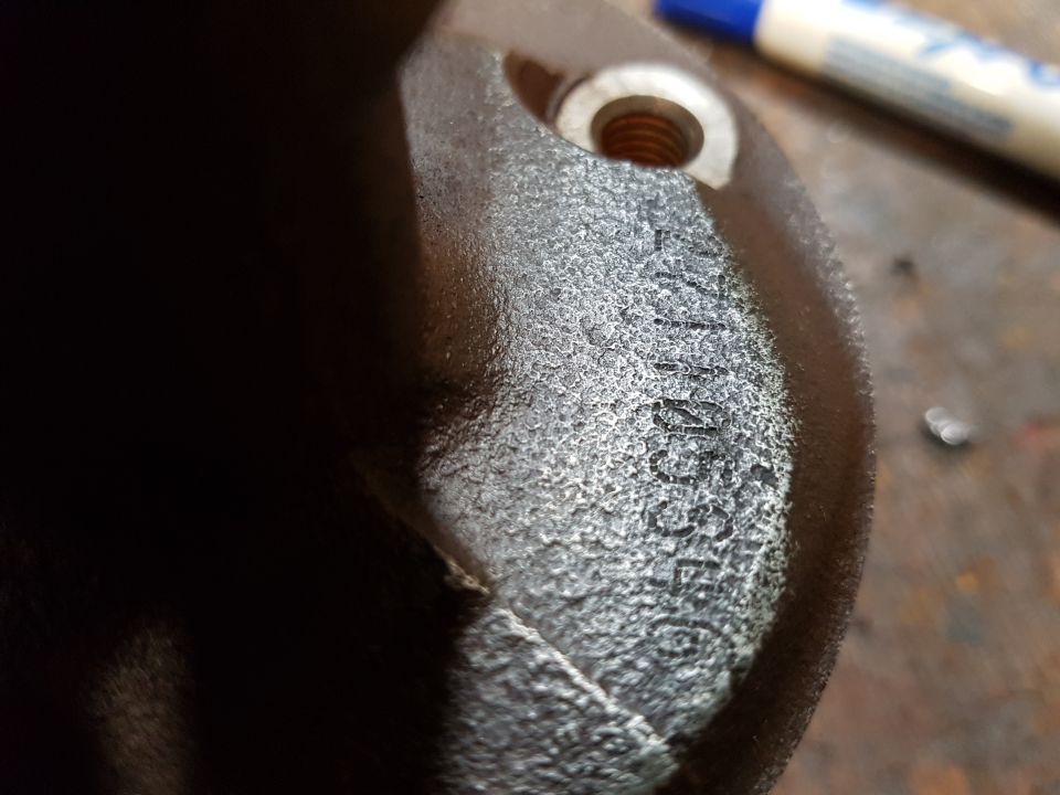 Close-up of a dark metal part with embossed text "71855E".