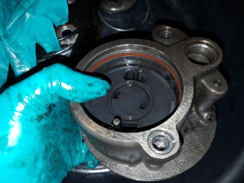 1978 Ford Bronco - A gloved hand holds a disassembled metal component with a red O-ring seal visible inside. The component has threaded holes and appears to b…