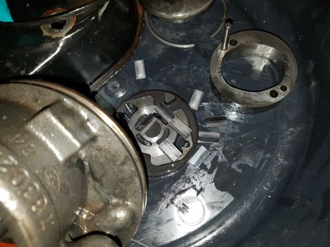 1978 Ford Bronco - A close-up view of disassembled internal components of a vehicle, likely a pump or transmission, resting in a dark container. Several metal…