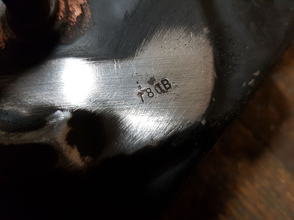 Close up of stamped text "78 DB" on a metallic surface of a vehicle part.