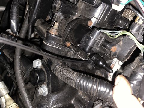 Black plastic sensor with wire on engine component