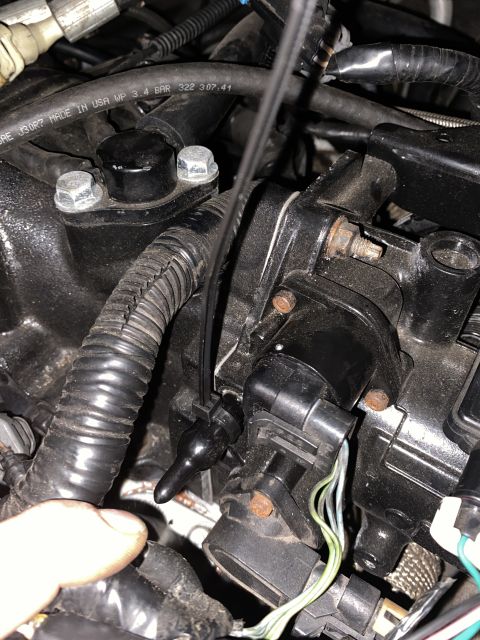 Engine components of a 2000 Pontiac Grand Prix, including sensors and hoses.