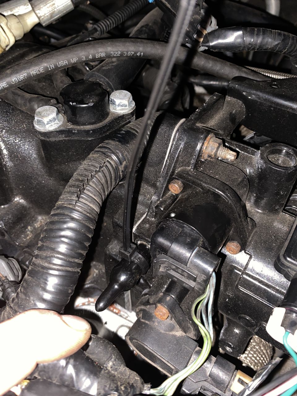 Engine components of a 2000 Pontiac Grand Prix, including sensors and hoses.