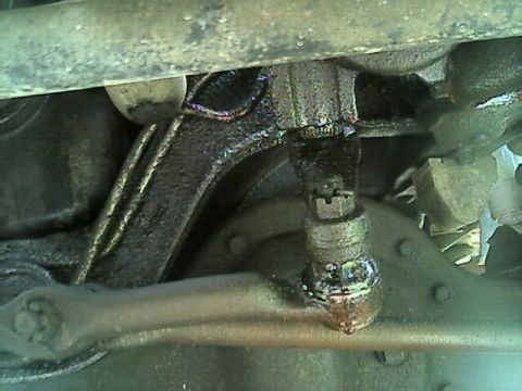 1989 Ford Bronco - Close-up view of the greasy underside of a vehicle, showing suspension components and a watermark.