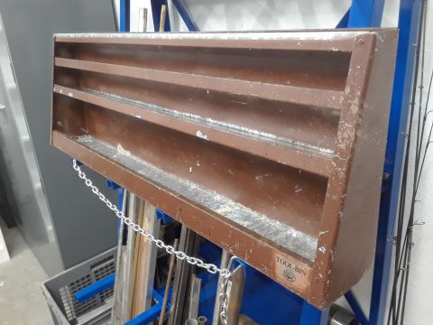 1994 Ford Bronco - A brown metal tool organizer with multiple shelves is mounted on a blue metal rack. A silver chain hangs from the organizer, and various me…