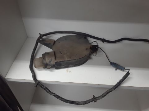 1994 Ford Bronco - A dusty, black fan assembly with electrical wiring is shown resting on a white shelf. The assembly appears to be a part from a vehicle, pos…