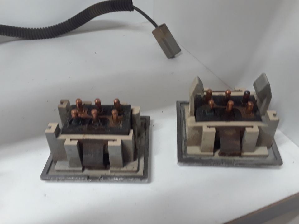 Two electrical relay switches with copper terminals and a black wire harness.