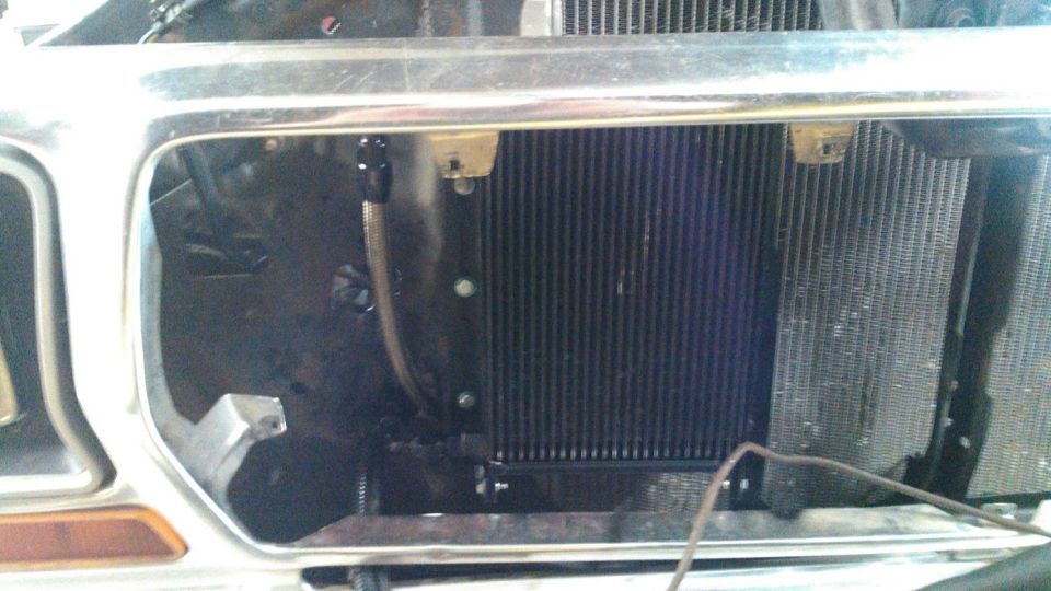 Close-up of a vehicle's radiator and auxiliary cooler behind a removed grille.
