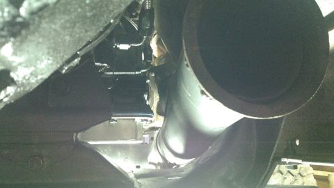 1978 Ford Bronco - This is a low-angle shot looking up at the underside of a vehicle, focusing on the exhaust system and frame components. A large, dark-color…