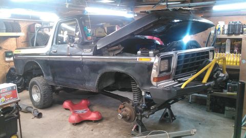 1978 Ford Bronco - 1978 Ford Bronco undergoing repairs in a workshop, front suspension visible.