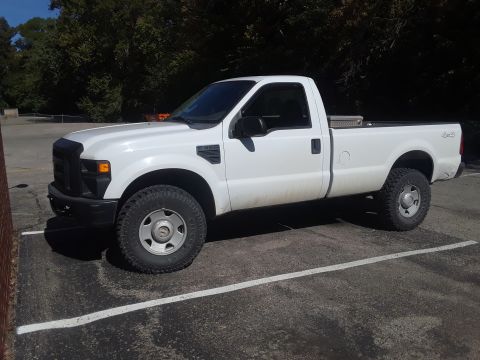 2008 Ford F-350 - A white 2008 Ford F-350 pickup truck is parked in a lot on a sunny day.