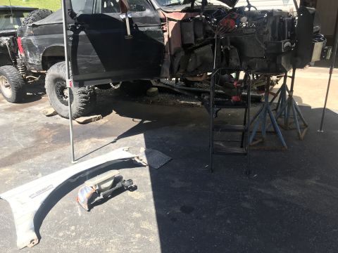 1989 Ford Bronco - Disassembled black Ford Bronco, likely from the late 1980s, undergoing repairs or modification.