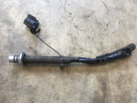 1989 Ford Bronco - A damaged metal part with an electrical connector and wire is shown on a concrete floor.