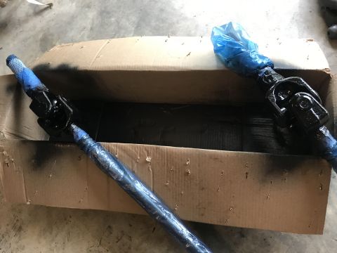 1989 Ford Bronco - Two steering shafts are shown in a cardboard box, one of them is partially covered with blue plastic wrap.
