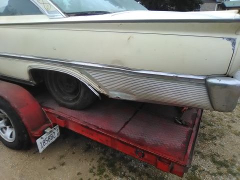 1961 Ford Starliner - A 1961 Ford Starliner is seen on a trailer, with visible damage to its rear quarter panel.