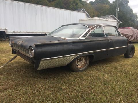 1961 Ford Starliner - This black 1960 Ford Fairlane 500 hardtop coupe is seen from the front three-quarter angle, parked on grass.