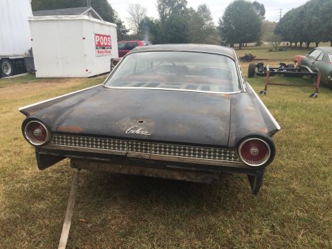 1961 Ford Starliner - Rear view of a 1961 Ford Galaxie, showing its distinctive taillights and grille. The car appears to be in need of restoration.