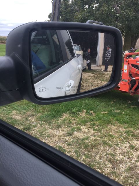 1961 Ford Starliner - Side mirror reflection captures a scene with people and farm equipment.
