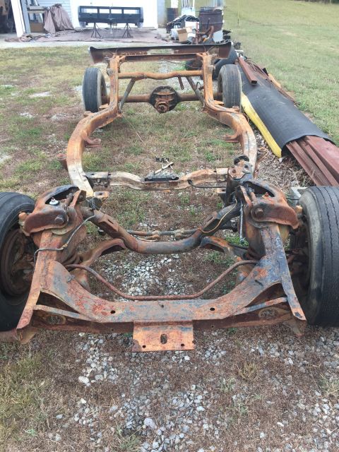 1961 Ford Starliner - This heavily rusted vehicle frame sits outdoors on a grassy area, awaiting restoration or parts.