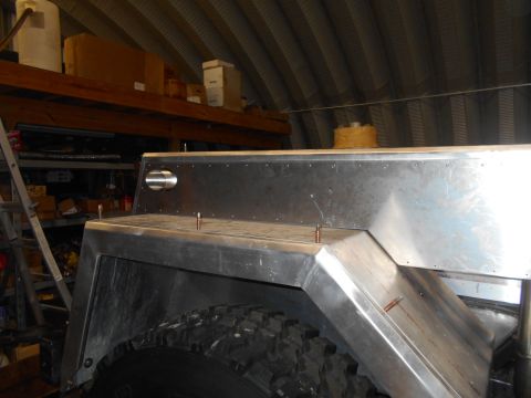 1992 Ford Bronco - Custom metal fender flare installed on a vehicle, seen in a workshop setting.