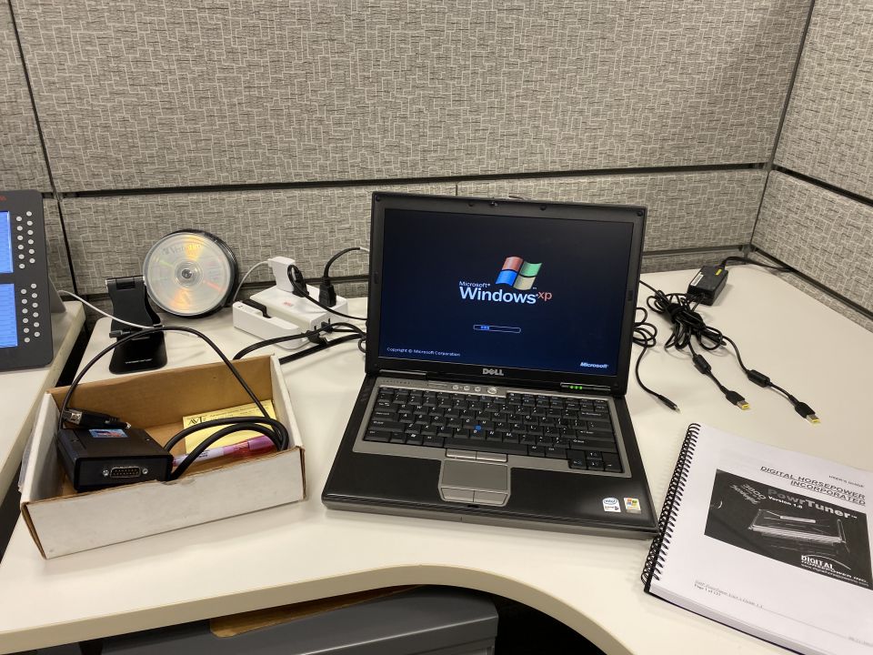 Laptop with Windows XP, diagnostic tool, and manual on a desk