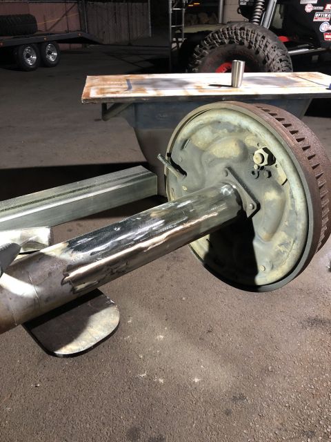 1986 Ford Bronco - A rear axle assembly with a brake drum is shown, with evidence of metal fabrication and rust.