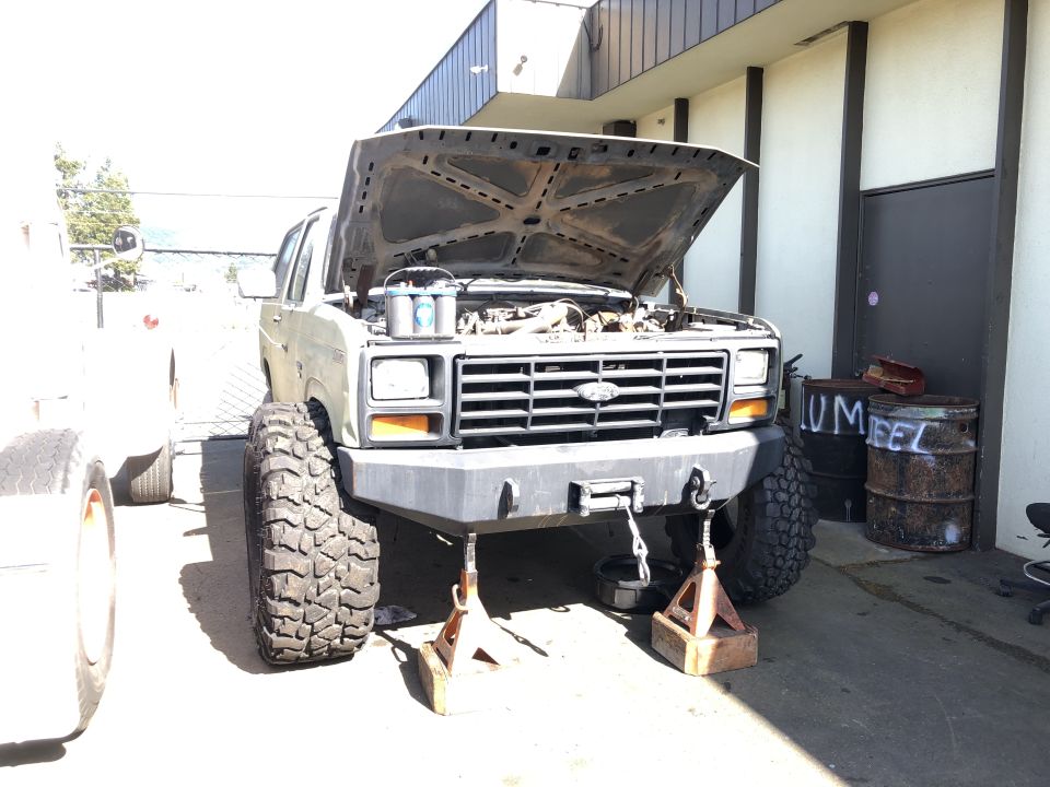 1986 Ford Bronco with hood open, lifted, and on jack stands