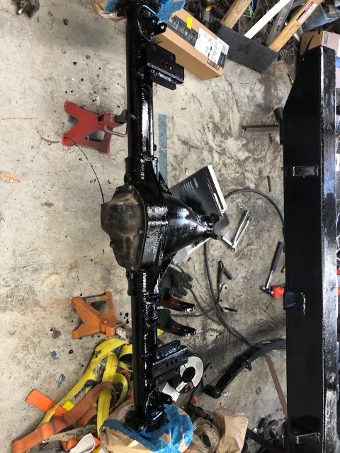 1992 Jeep Wrangler - Rear axle assembly and leaf springs on jack stands, likely undergoing restoration or repair.