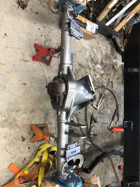 1992 Jeep Wrangler - A vehicle's rear axle assembly is shown, supported by jack stands in a workshop setting.