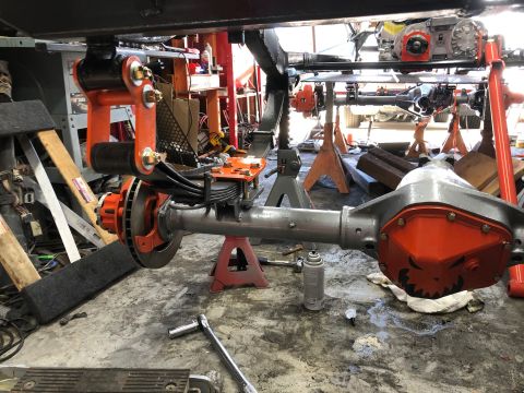 1992 Jeep Wrangler - Close-up view of a Jeep Wrangler's rear axle and suspension system, orange accents and brake components.