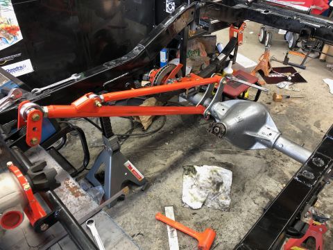 1992 Jeep Wrangler - The rear axle assembly and suspension components are visible on a vehicle frame supported by jack stands.