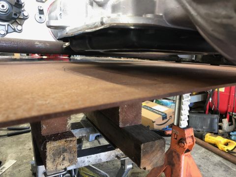 1992 Jeep Wrangler - Close-up view of a vehicle's undercarriage, showing the frame and transmission supported by blocks and stands.