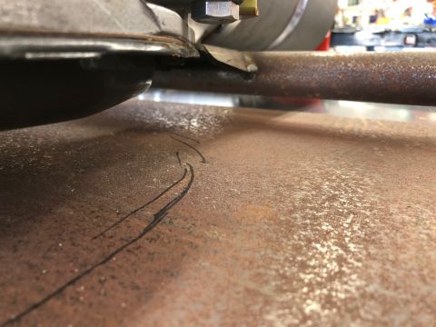 1992 Jeep Wrangler - Close-up view of a rusty frame section with black markings, likely a part of a vehicle's undercarriage.