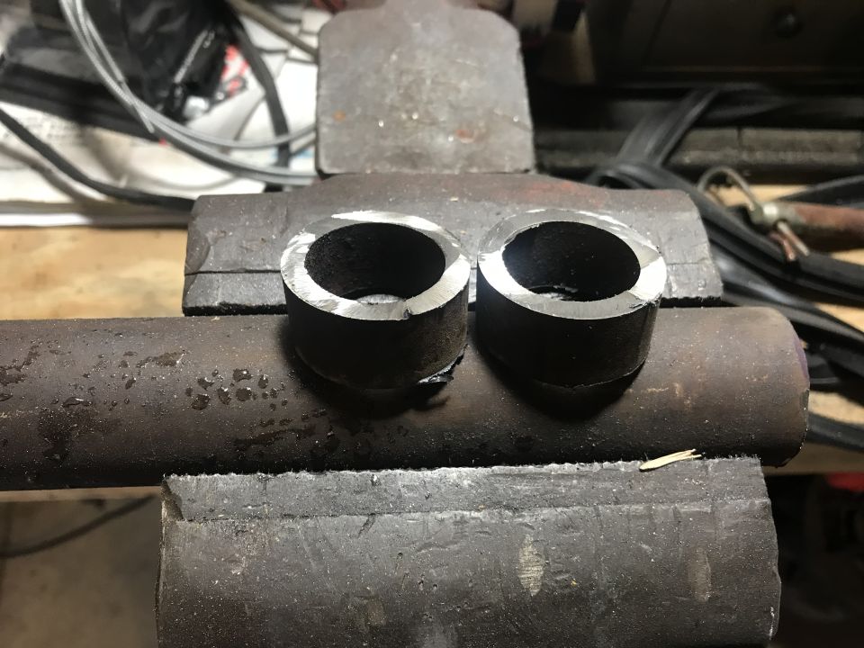 Two cut metal pipe sections clamped in a vise