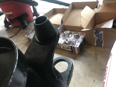 1989 Ford Bronco - Close-up of a black metal part, likely a suspension component, with new bearings visible in the background.