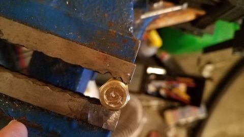 1985 Ford Bronco - A brass fitting is secured in a vise, suggesting a mechanical repair or fabrication process.