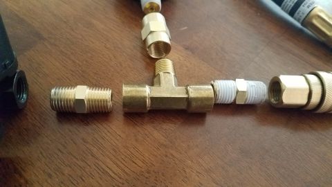 1985 Ford Bronco - Brass pipe fittings are laid out on a wooden surface, appearing to be part of a homemade tool.
