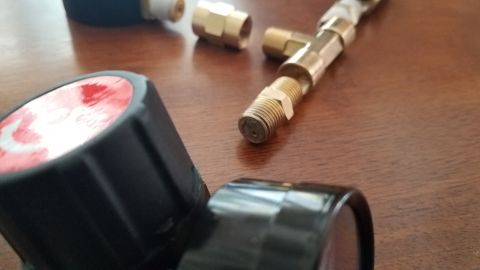 1985 Ford Bronco - This image shows parts of a homemade leakdown tester, including brass fittings and black gauges, not a 1985 Ford Bronco.