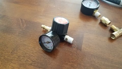 1985 Ford Bronco - Air pressure regulator and fittings are shown on a wooden table.