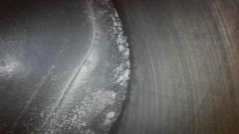 1985 Ford Bronco - This image shows a close-up of a worn tire tread with visible damage and debris.