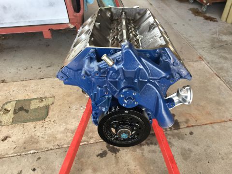 1974 Ford F-100 - A blue painted V8 engine block is shown on a red engine stand, with a Supermotors.net watermark at the bottom right.