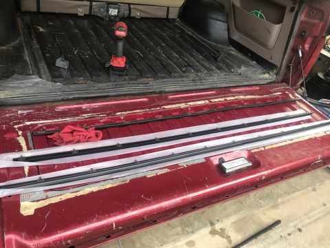 1994 Ford Bronco - The tailgate of a 1994 Ford Bronco is open, revealing new weather stripping and a drill.