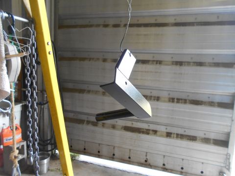 1992 Ford Bronco - A metal part, possibly a trailer hitch component, is suspended and painted in a garage setting.