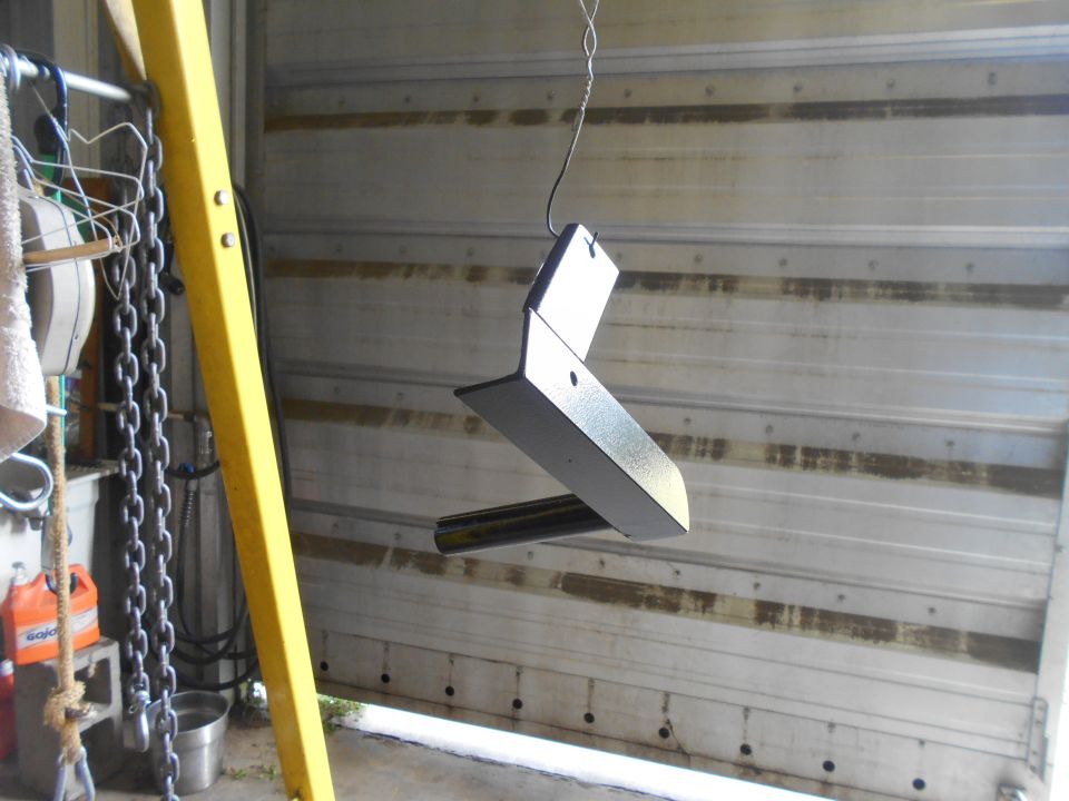 Painted metal part hanging in garage