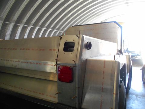 1992 Ford Bronco - Unfinished custom truck bed shows red lettering and a single taillight under a corrugated metal roof.