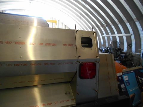 1992 Ford Bronco - The rear section of a vehicle is shown in a workshop, with visible metal sheeting and construction markings.